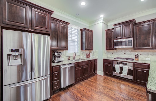 kitchen featuring dark wood-type flooring, appliances with stainless steel finishes, light stone countertops, and sink