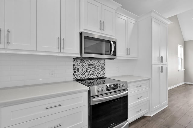 kitchen featuring white cabinetry, appliances with stainless steel finishes, dark hardwood / wood-style flooring, and decorative backsplash