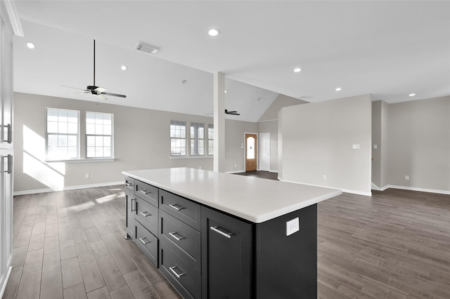 kitchen featuring dark hardwood / wood-style flooring, a center island, and ceiling fan