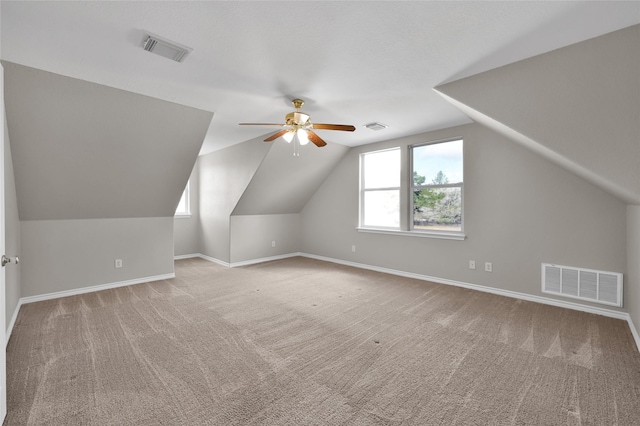 additional living space featuring vaulted ceiling, light colored carpet, and ceiling fan