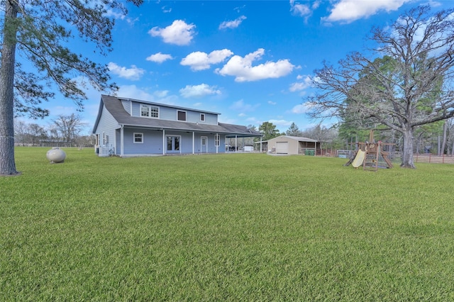 back of property with a playground and a lawn