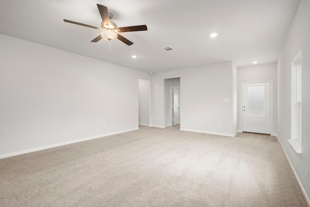 spare room with ceiling fan and light carpet