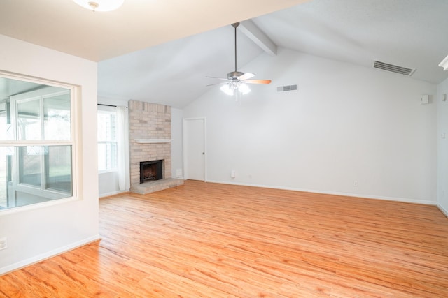 unfurnished living room with ceiling fan, lofted ceiling with beams, a brick fireplace, and light wood-type flooring