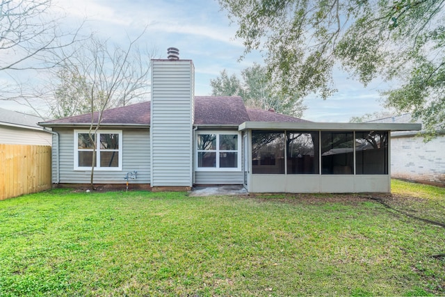 rear view of property featuring a sunroom and a lawn