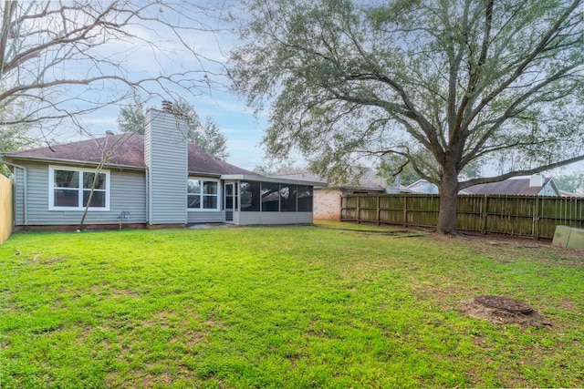 back of house featuring a sunroom and a lawn