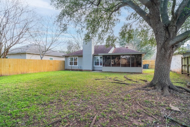 back of property with a sunroom and a lawn