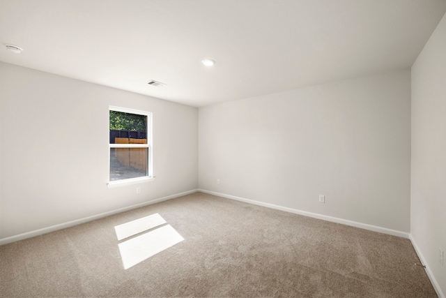 carpeted spare room with baseboards and visible vents