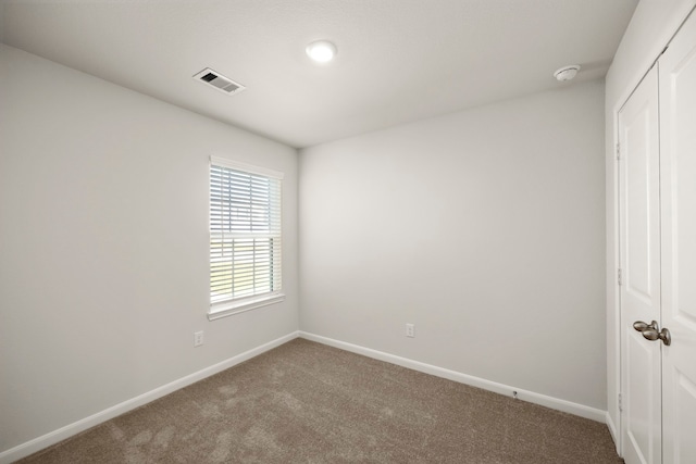 unfurnished bedroom featuring carpet, visible vents, baseboards, and a closet