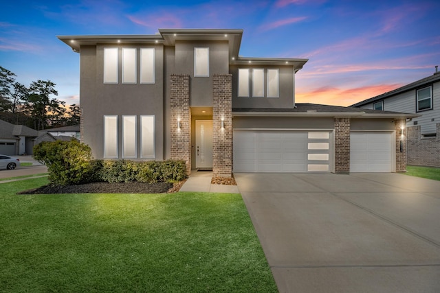 view of front of home with a garage and a yard