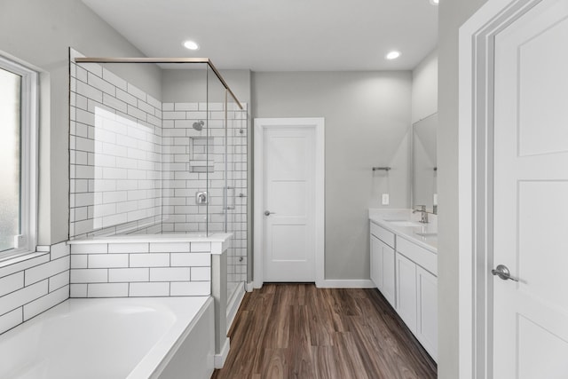 bathroom with hardwood / wood-style flooring, vanity, and shower with separate bathtub