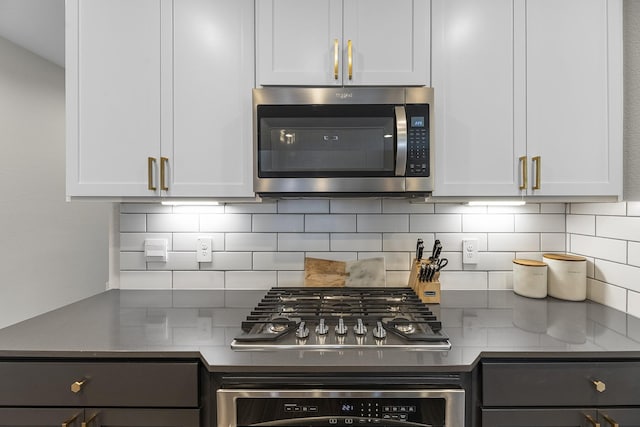 kitchen featuring stainless steel appliances, white cabinets, and decorative backsplash