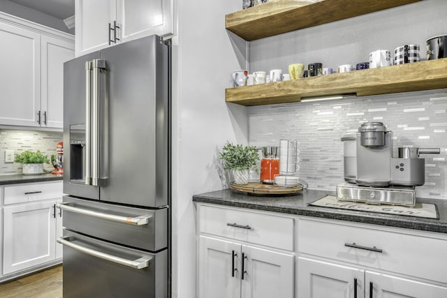 kitchen featuring high quality fridge, white cabinets, backsplash, and light hardwood / wood-style flooring