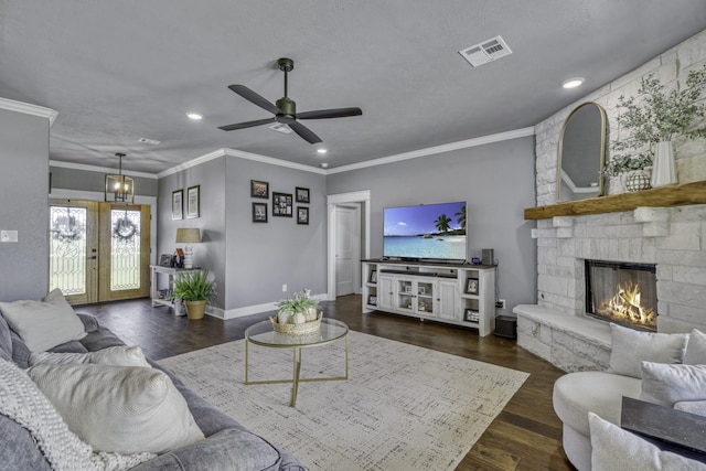 living room featuring ornamental molding, dark hardwood / wood-style floors, a fireplace, and french doors