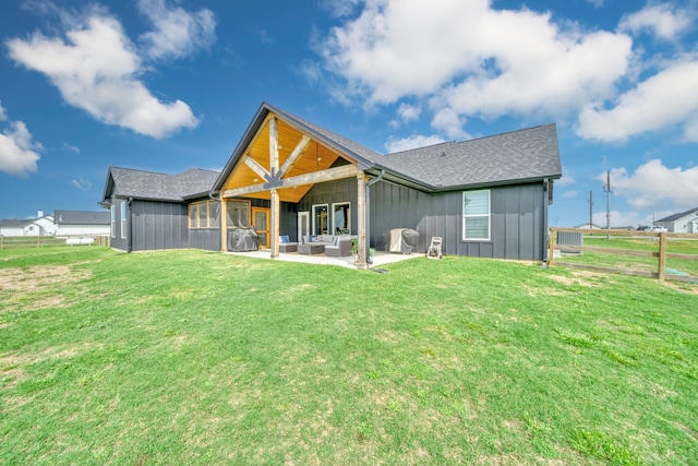 rear view of property featuring a yard, an outdoor living space, and a patio area