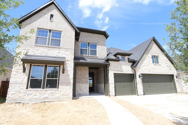 traditional home with driveway, an attached garage, and stone siding