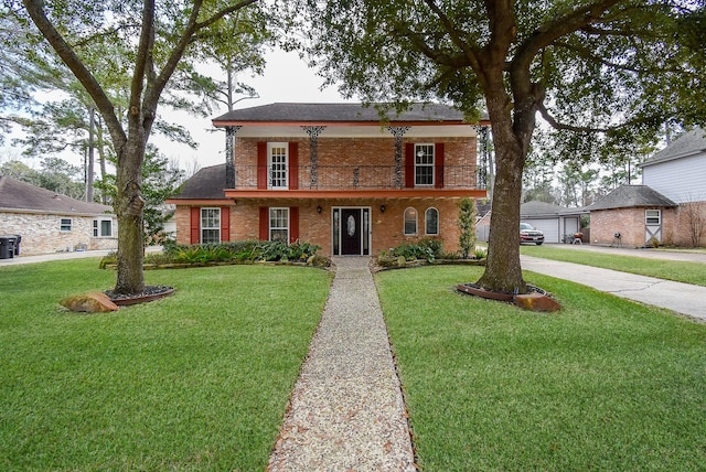 view of front facade with a balcony, a garage, and a front yard