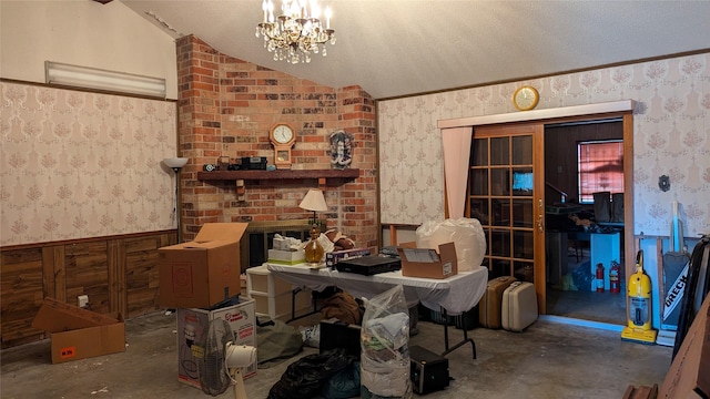 misc room with vaulted ceiling, a chandelier, a fireplace, and a textured ceiling