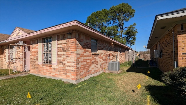 view of property exterior featuring a lawn and central air condition unit