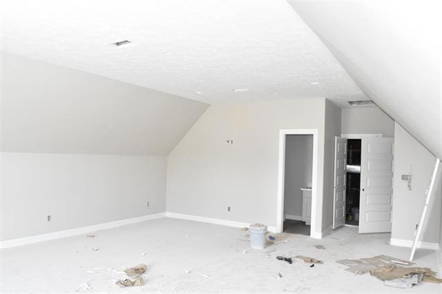 additional living space featuring lofted ceiling