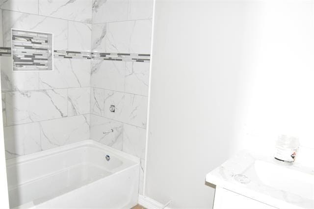 bathroom with vanity and tiled shower / bath