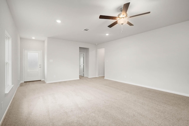 unfurnished room with light colored carpet and ceiling fan