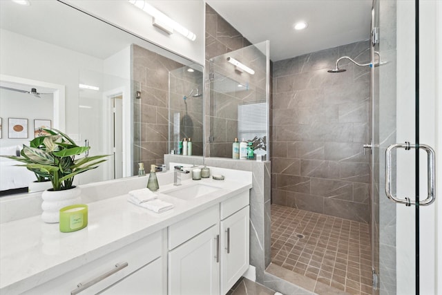 bathroom featuring a shower with door and vanity