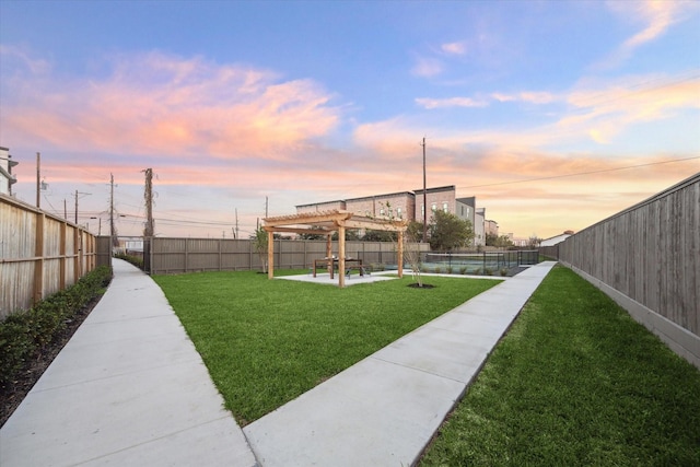 yard at dusk featuring a pergola and a patio area