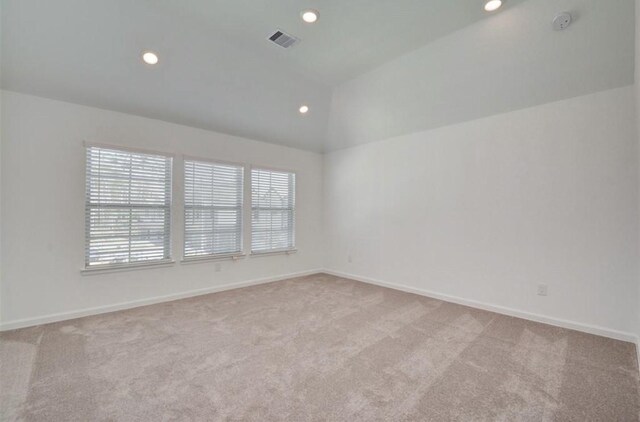 carpeted empty room with lofted ceiling