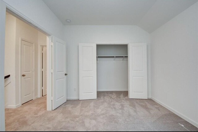 unfurnished bedroom featuring a closet and light carpet