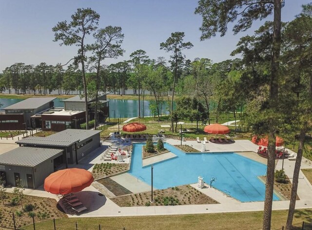 view of swimming pool featuring a patio and a water view