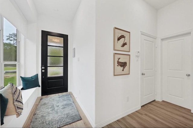 entrance foyer with baseboards and light wood-style floors