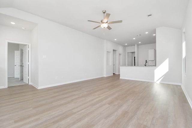 unfurnished living room with sink, ceiling fan, and light wood-type flooring