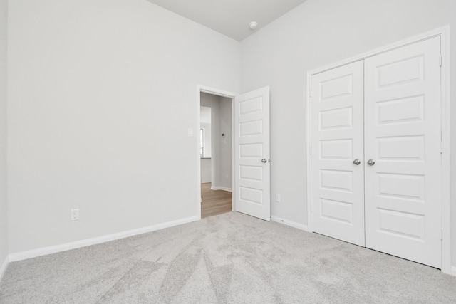 unfurnished bedroom with a closet and light carpet