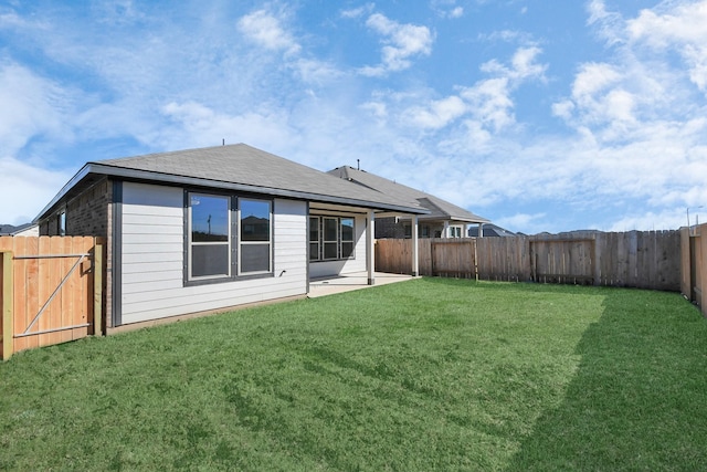 rear view of house with a patio and a yard