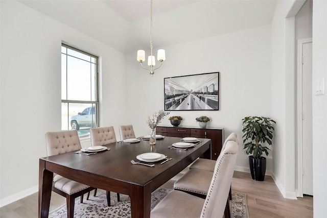 dining space with an inviting chandelier and light hardwood / wood-style flooring