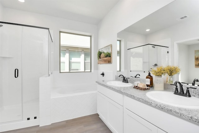 bathroom featuring independent shower and bath, wood-type flooring, and vanity