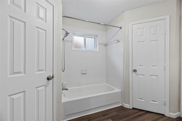 bathroom featuring tiled shower / bath, hardwood / wood-style flooring, and a textured ceiling