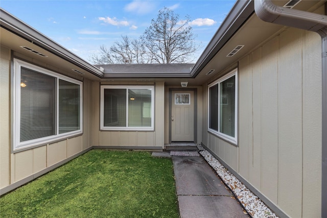 doorway to property with a lawn