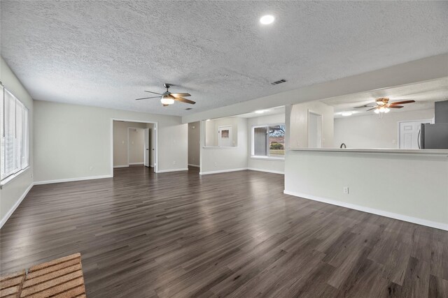 unfurnished living room with dark hardwood / wood-style floors, a textured ceiling, and ceiling fan