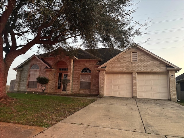 ranch-style home with a garage and a lawn