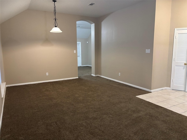 carpeted empty room featuring lofted ceiling