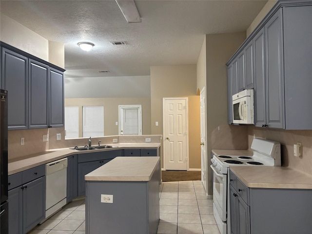 kitchen featuring a kitchen island, sink, gray cabinetry, and white appliances