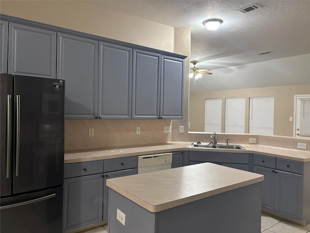 kitchen featuring sink, black refrigerator, dishwasher, a kitchen island, and ceiling fan