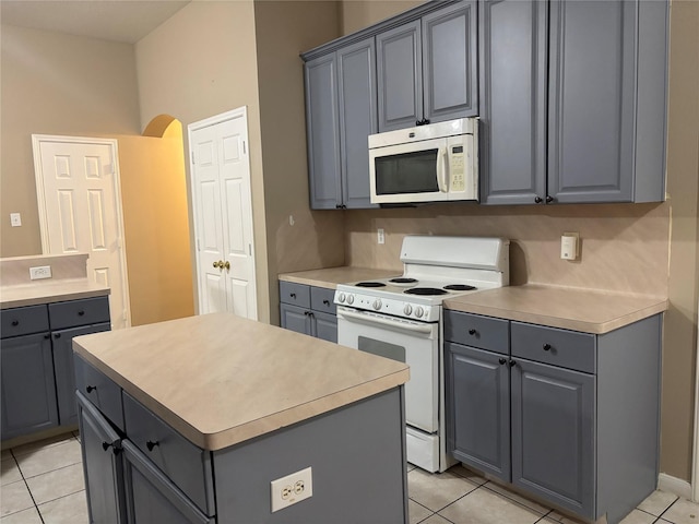 kitchen with white appliances, gray cabinets, and a kitchen island