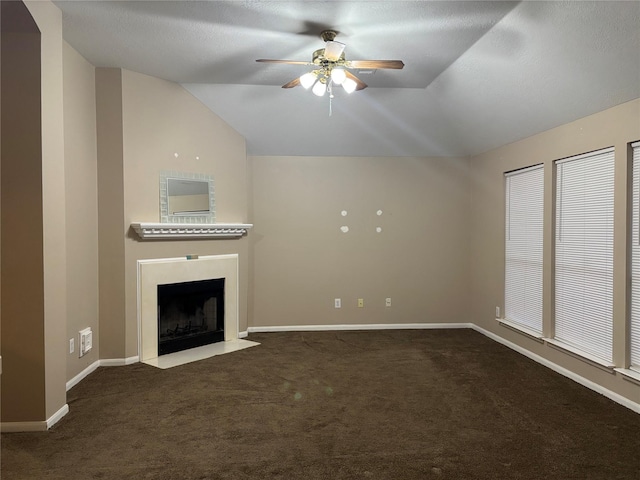 unfurnished living room with ceiling fan, lofted ceiling, and dark carpet