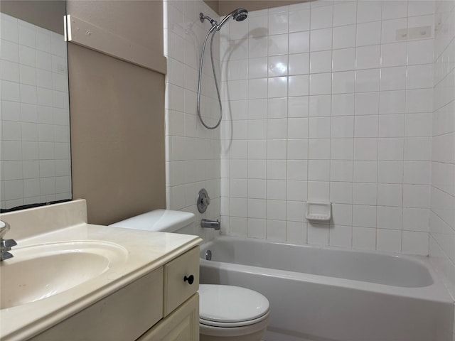 full bathroom featuring tiled shower / bath, vanity, and toilet