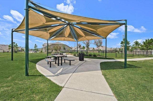 view of property's community featuring a yard, a patio area, and fence