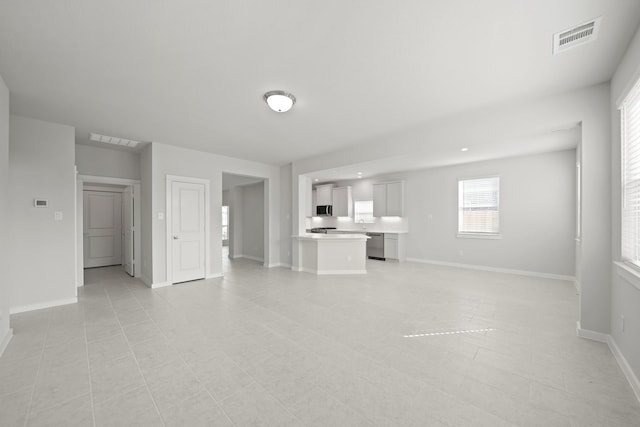 unfurnished living room with visible vents and baseboards