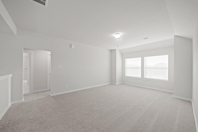 spare room with visible vents, light colored carpet, and baseboards