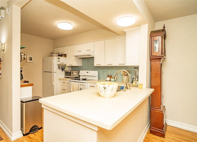 kitchen featuring white appliances, backsplash, light hardwood / wood-style floors, white cabinets, and kitchen peninsula